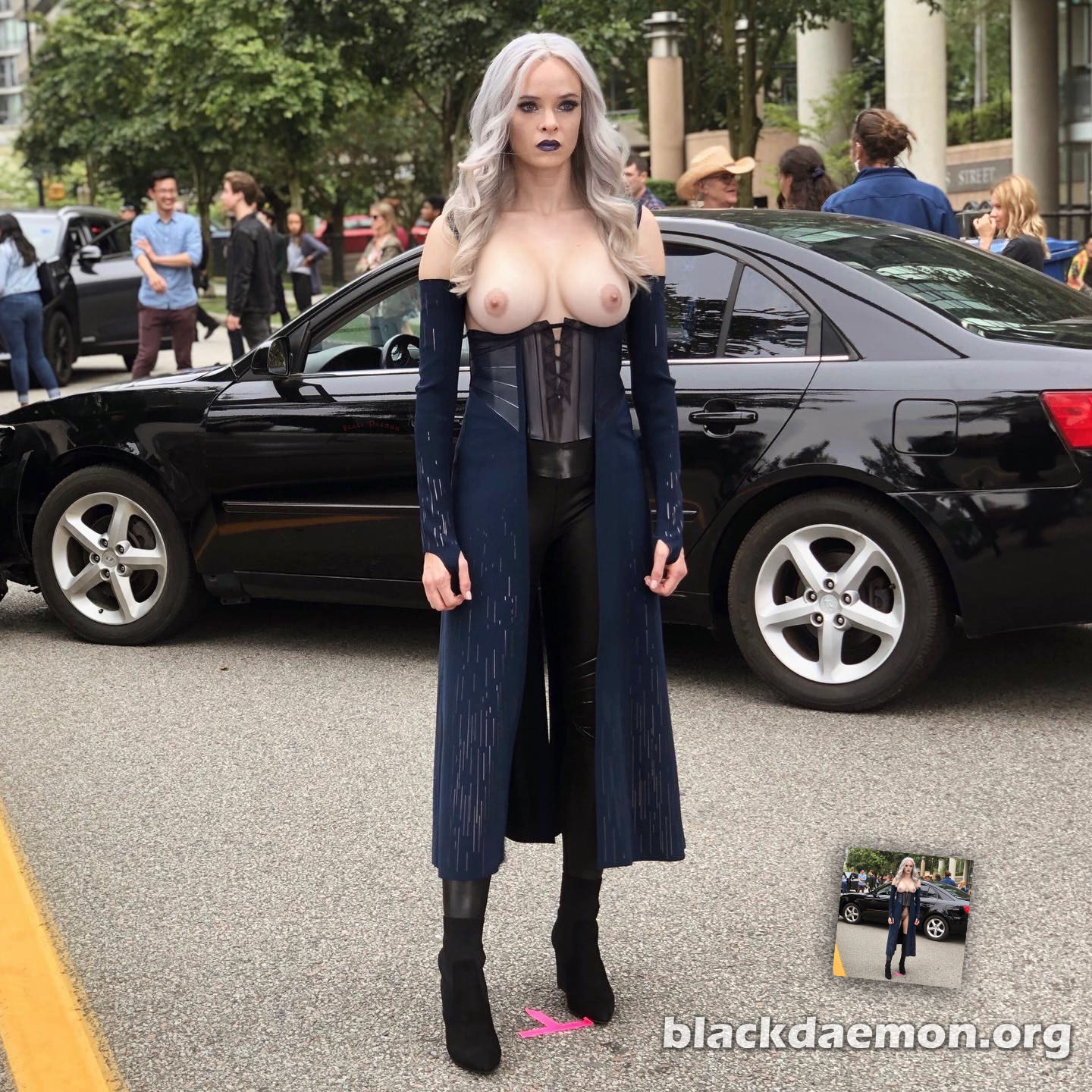 Danielle Panabaker standing in front of a black car in a parking lot.
